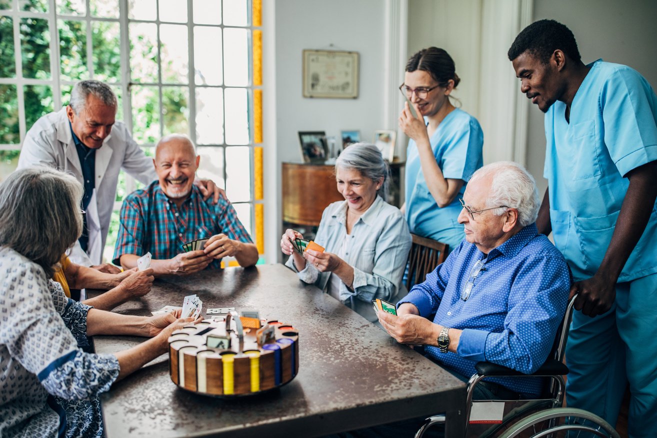 Senior friends playing cards in nursing home